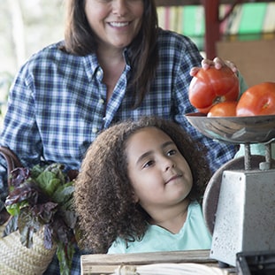 Mother and daughter buying tomatoes