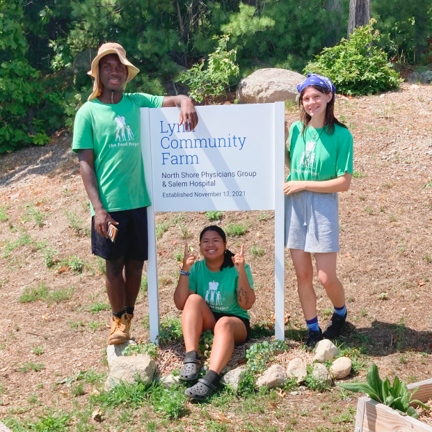 three people standing around a sign