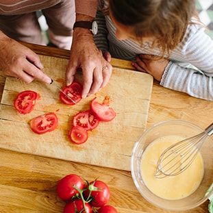 Mom and daughter cutting tomatoes for dinner