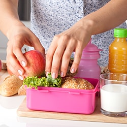 Mom filling child's lunchbox